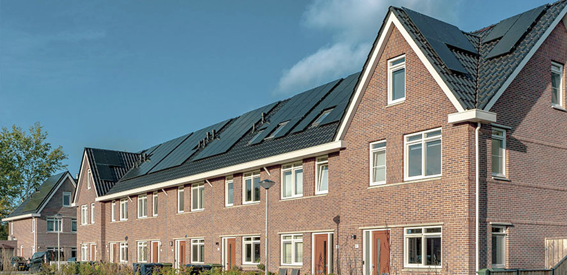 Straatbeeld van nieuwbouwwoningen met zonnepanelen.