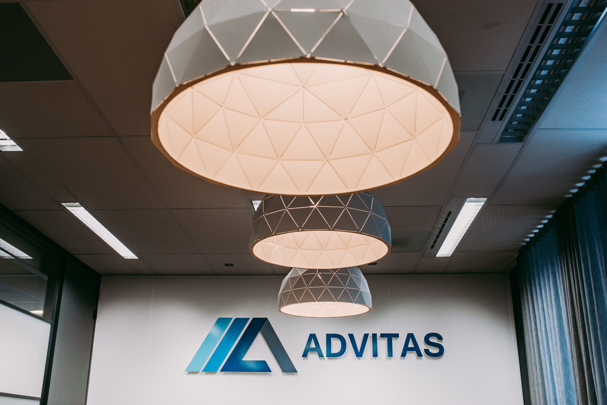 Drie lampen op een rij met op de achtergrond het Advitas-logo.