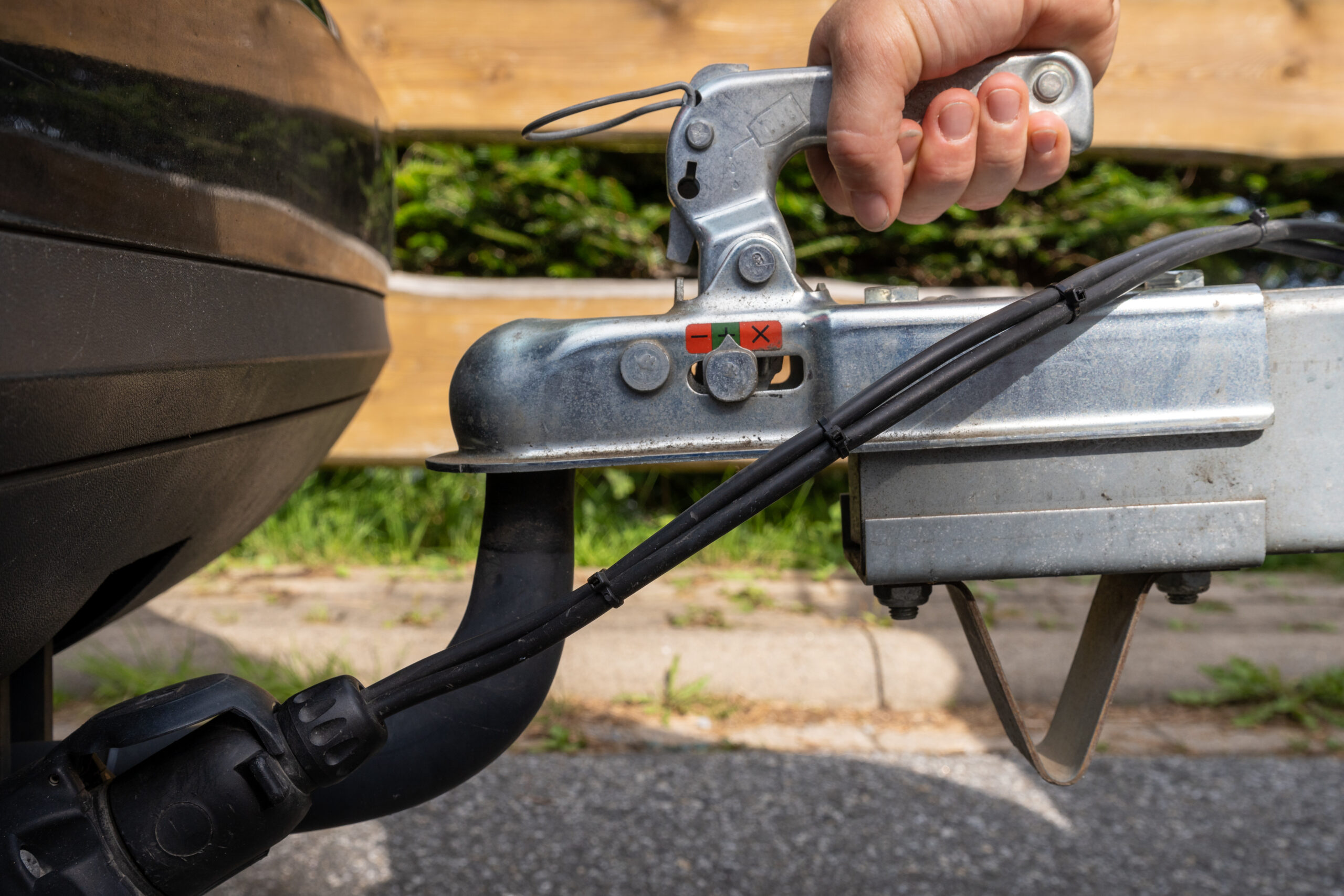 controleert de bevestiging van het gesloten trekhaakslotenhandvat op de trekbal van de auto, close-up.
