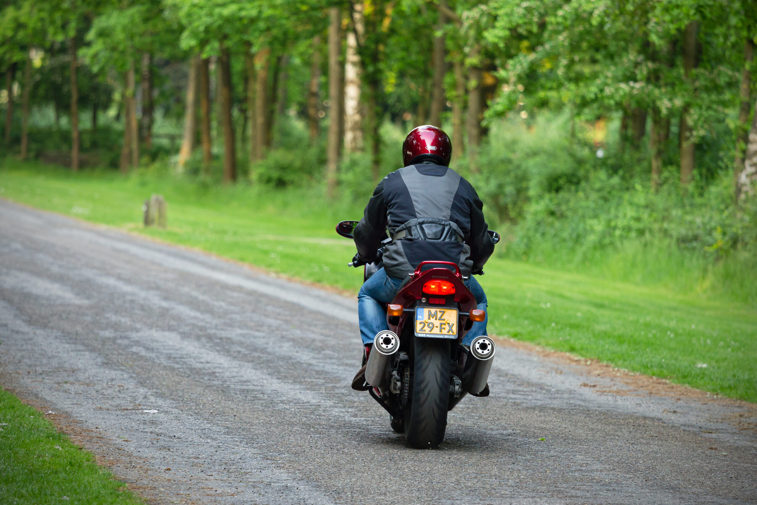 Achteraanzicht van een motorrijder in de natuur.