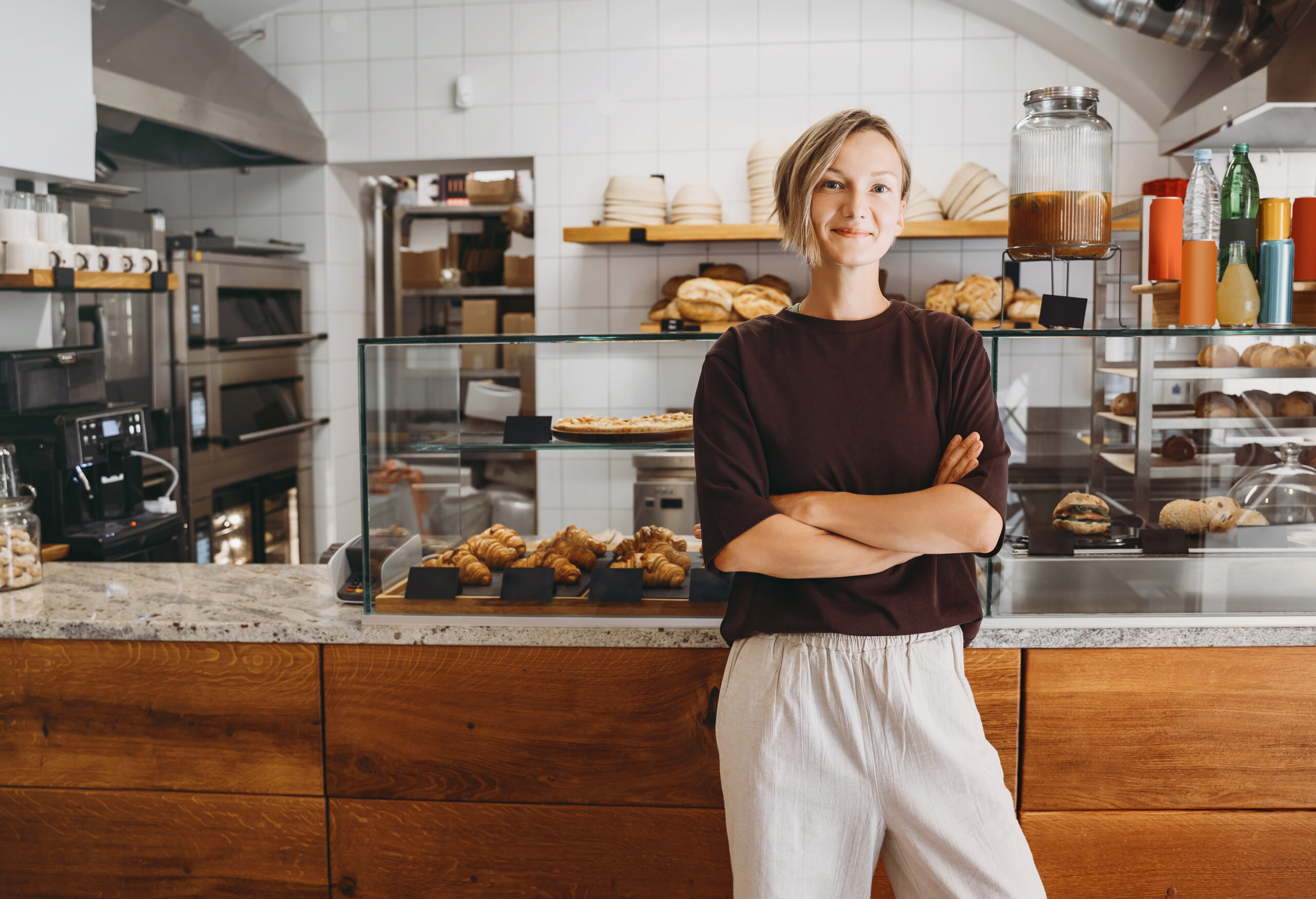 Portret van lachende jonge vrouw, eigenaresse van een lokale bakkerij en koffiezaak