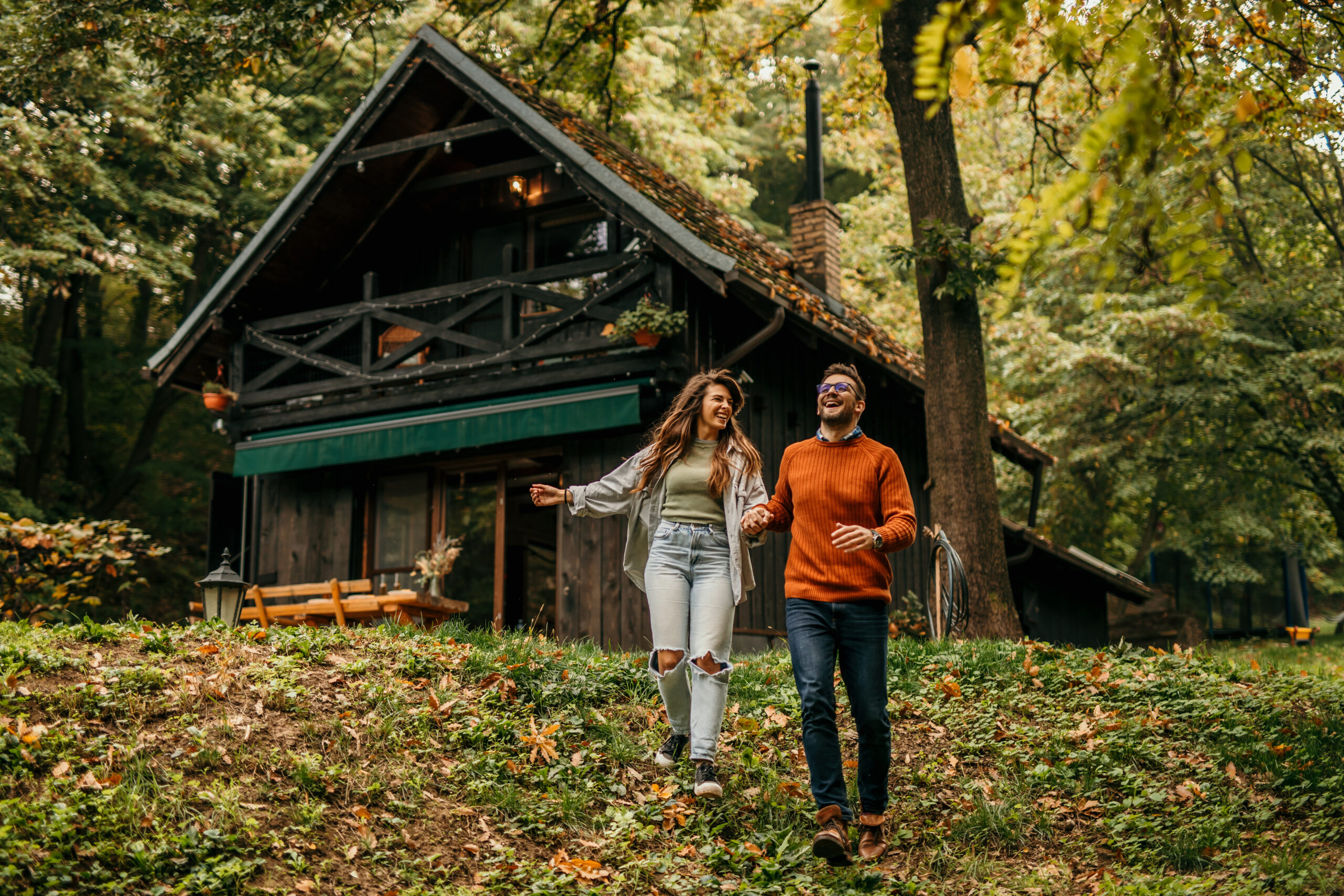 Man en vrouw buiten bij een huis, blij in de natuur