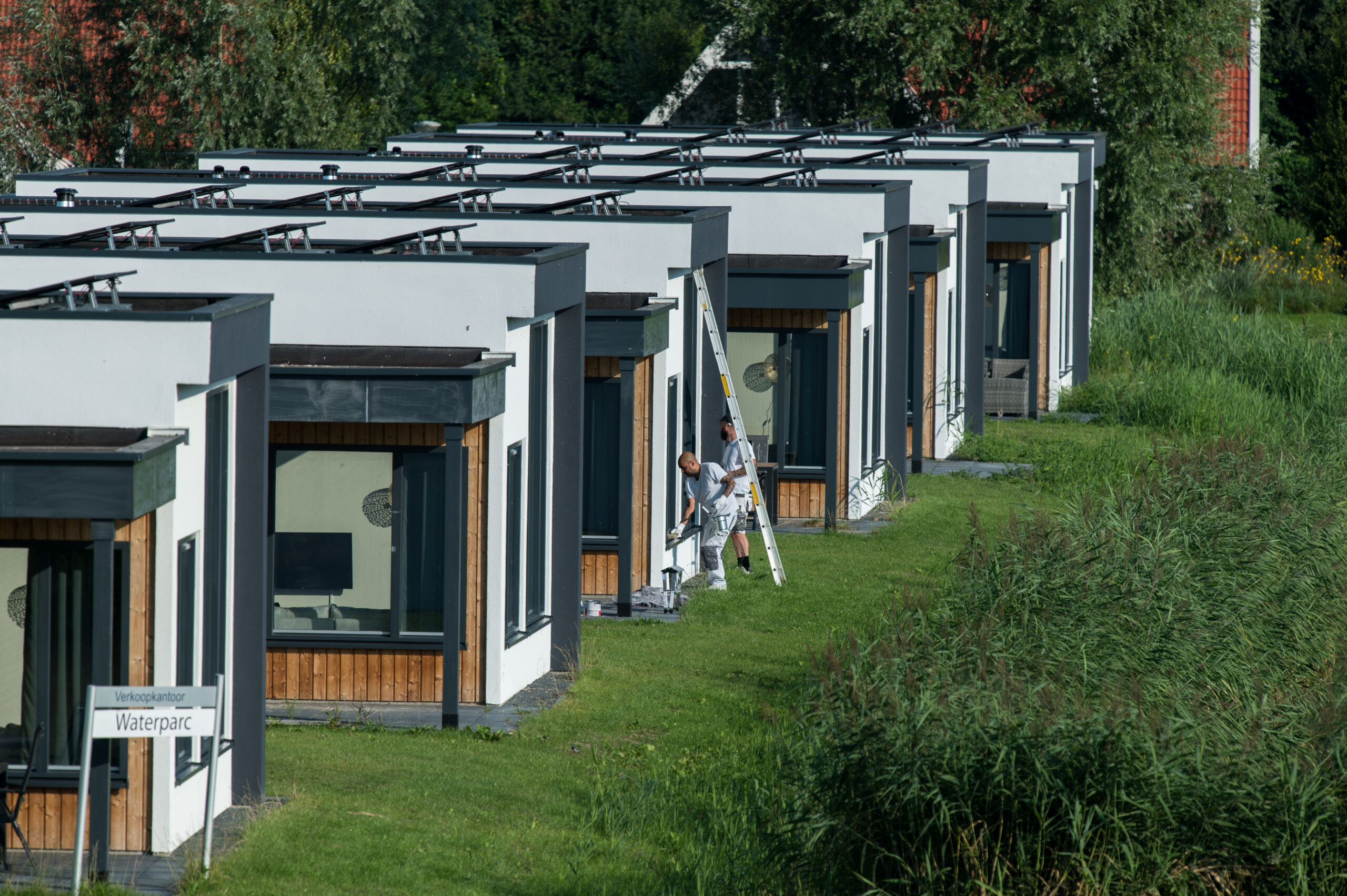 Park met huisjes waar schilders aan het werk zijn.