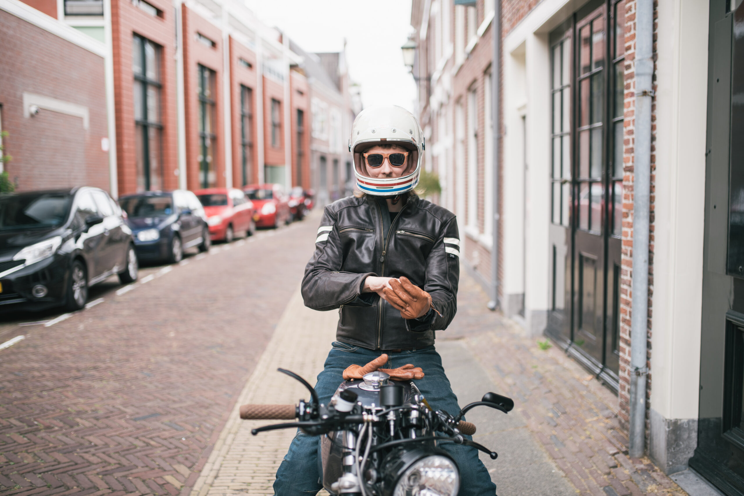 Man op een motor geparkeerd langs de straatkant.