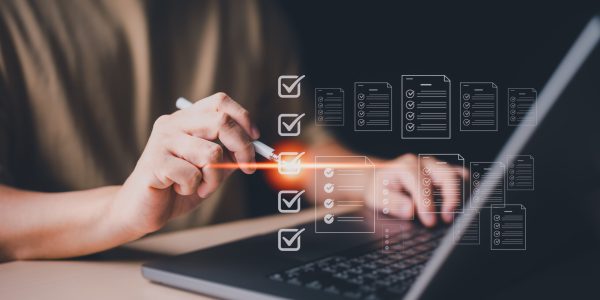Businessman use a laptop to take online surveys with digital forms and checklists. Technology and strategy for success in modern business trends. Efficiency, transparency in organization and company.
